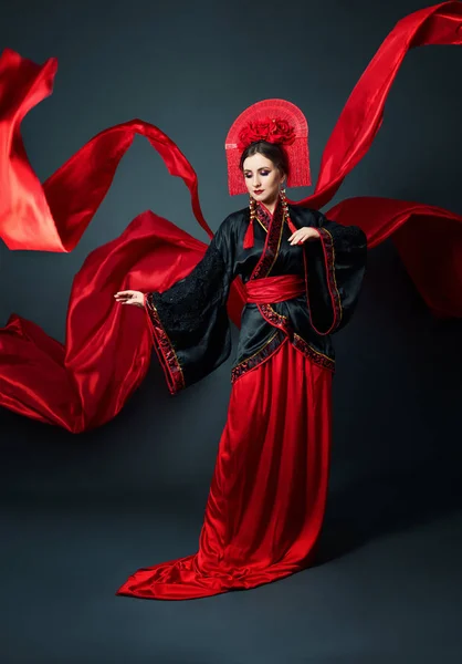 Woman is dressed in red Chinese Japanese folk clothing. Flying f — 스톡 사진