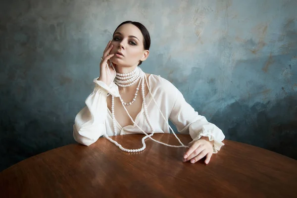 Girl dressed in white boho clothing with white pearl beads aroun — Stock Photo, Image