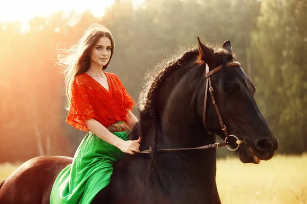 Gypsy girl rides a horse in a field in the summer. A woman with — Stock Photo, Image