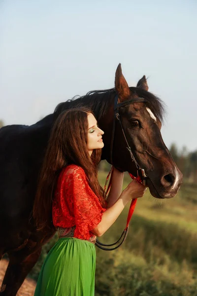 Zigeunermeisje rijdt in de zomer op een paard in een veld. Een vrouw met — Stockfoto