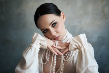 Beyaz boho elbiseli, beyaz inci boncuklu bir kız.