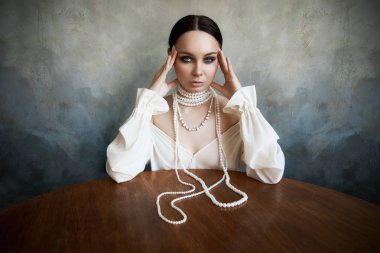 Beyaz boho elbiseli, beyaz inci boncuklu bir kız.