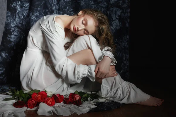 Menina bela primavera está sentado no chão com flores de rosa — Fotografia de Stock