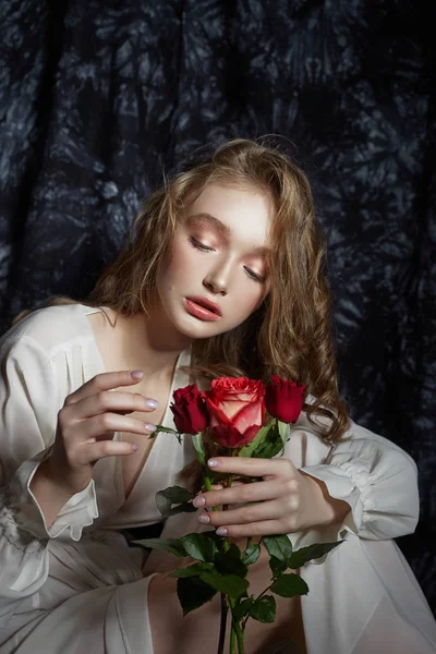 Bella ragazza di primavera è seduta sul pavimento con fiori di rosa — Foto Stock