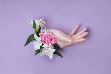 Mor bir arka planda delikte çiçekli Güzel El.