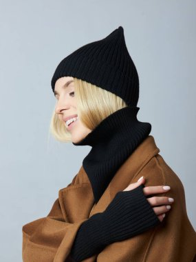 Palto giymiş bir kadın, bahar kıyafetleri, bir Snood atkısı, bir şapka ve eldiven.. 