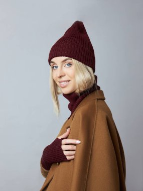 Palto giymiş bir kadın, bahar kıyafetleri, bir Snood atkısı, bir şapka ve eldiven.. 