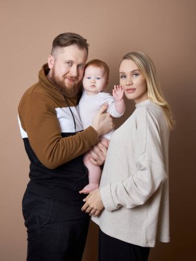Bir erkek ve bir kadın bir bebeği kollarında tutuyorlar. Evli birinin portresi.