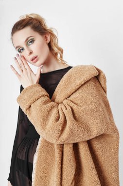 Paltolu bir kadın, yüzünde yaratıcı bahar makyajı. Büyük ekspres