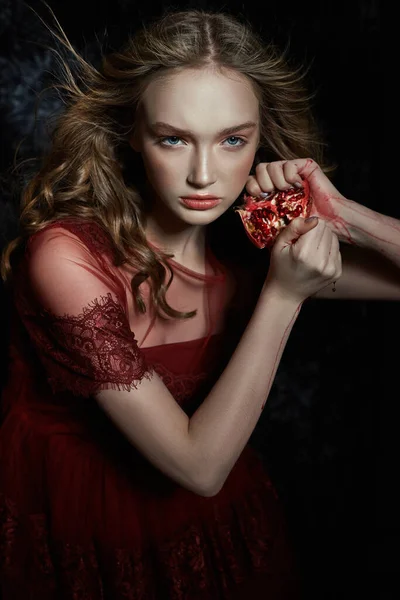 Beautiful blonde girl with pomegranate fruit in her hands. Sprin — Stock Photo, Image