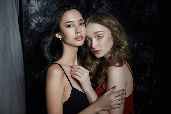 Retrato de primavera de beleza de duas meninas em um fundo escuro. Mulheres — Fotografia de Stock