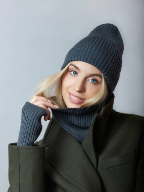 Palto giymiş bir kadın, bahar kıyafetleri, bir Snood atkısı, bir şapka ve eldiven.. 