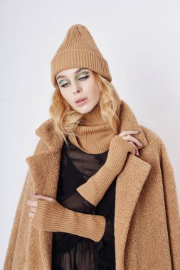 Paltolu bir kadın, yüzünde yaratıcı bahar makyajı. Büyük ekspres