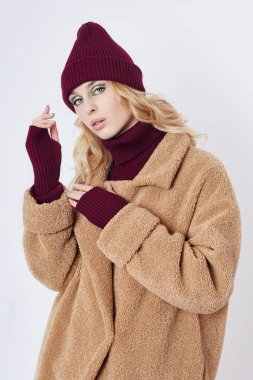 Paltolu bir kadın, yüzünde yaratıcı bahar makyajı. Büyük ekspres