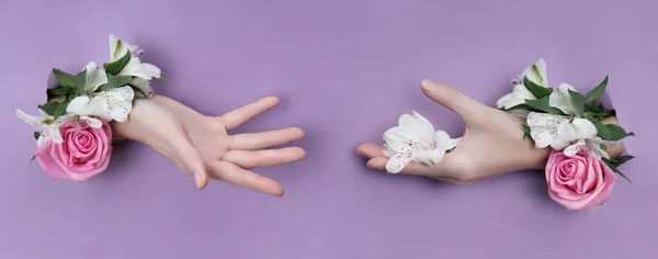 Belleza Mano con flores en un agujero en un fondo de papel morado . —  Fotos de Stock