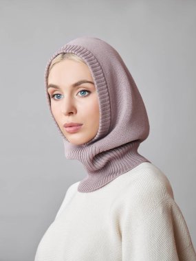 Kafasında başlık olan, sarı saçlı, Avrupalı Müslüman bir kadın. Yumuşak ciltli, doğal kozmetik ürünleri olan güzel bir kız.