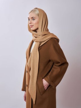 Kafasında başörtüsü olan sarı saçlı Avrupalı Müslüman kadın. Yumuşak ciltli, doğal kozmetik ürünleri olan güzel bir kız.