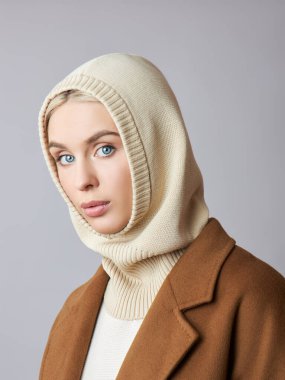 Kafasında başlık olan, sarı saçlı, Avrupalı Müslüman bir kadın. Yumuşak tenli güzel bir kız, doğal kozmetik ürünleri.