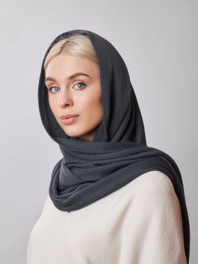 Kafasında başörtüsü olan sarı saçlı Avrupalı Müslüman kadın. Yumuşak ciltli, doğal kozmetik ürünleri olan güzel bir kız.