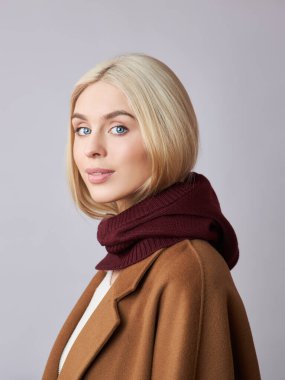 Kafasında başlık olan, sarı saçlı, Avrupalı Müslüman bir kadın. Yumuşak tenli güzel bir kız, doğal kozmetik ürünleri.