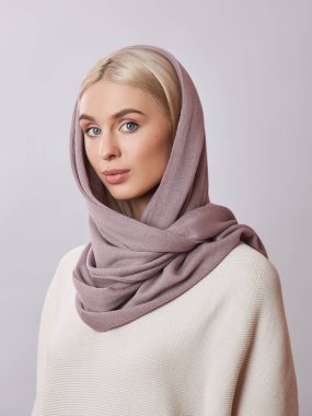 Kafasında başörtüsü olan sarı saçlı Avrupalı Müslüman kadın. Yumuşak ciltli, doğal kozmetik ürünleri olan güzel bir kız.