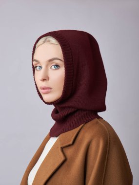 Kafasında başlık olan, sarı saçlı, Avrupalı Müslüman bir kadın. Yumuşak tenli güzel bir kız, doğal kozmetik ürünleri.