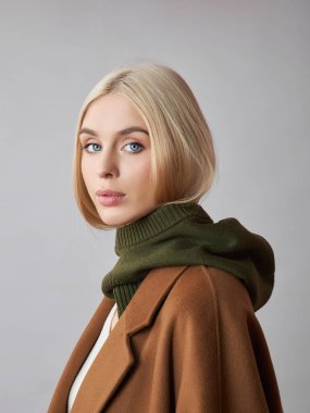 Kafasında başlık olan, sarı saçlı, Avrupalı Müslüman bir kadın. Yumuşak tenli güzel bir kız, doğal kozmetik ürünleri.