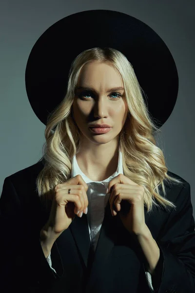 Portrait of a Blonde woman in a big round black hat, hair styling