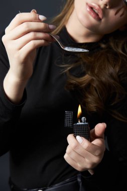 Kadın elinde bir kaşıkla sim kozmetik bir ilaç tutuyor. Kozmetik ve makyaja bağımlılık
