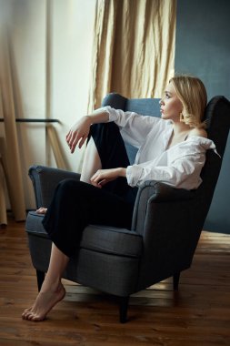 Kulaklarında mücevher küpeleri olan sarışın bir kadının hayat tarzı portresi. Güzellik yüzü pürüzsüz cilt, doğal kozmetik ve makyaj