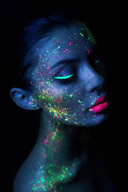 Neon ışıklı parlak floresan makyajlı manken kadın, yüz üstü yere düştü. Güzel model esmer kız renkli makyaj, boyalı ten, vücut tasarımı morötesi.