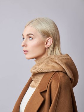 Kafasında başlık olan, sarı saçlı, Avrupalı Müslüman bir kadın. Yumuşak tenli güzel bir kız, doğal kozmetik ürünleri.