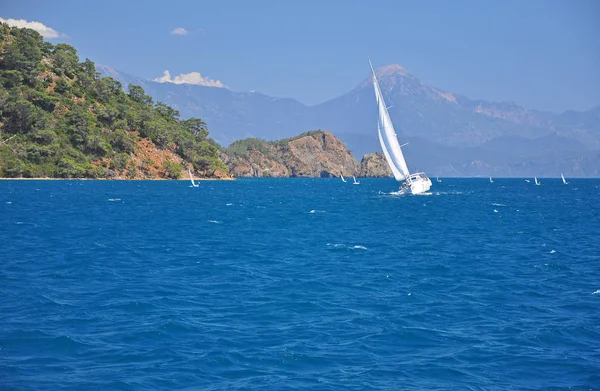White yachts with mountains and blue sky