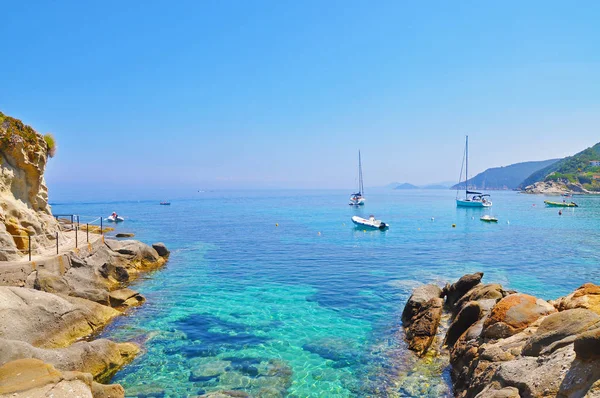 Azure stone shore and boats in the sea — Stock Photo, Image
