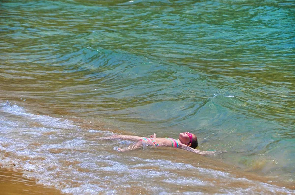 Dívka leží v moři, čeká na vlny — Stock fotografie