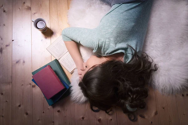 Açık bir kitap üzerinde uyuyan genç kadın — Stok fotoğraf