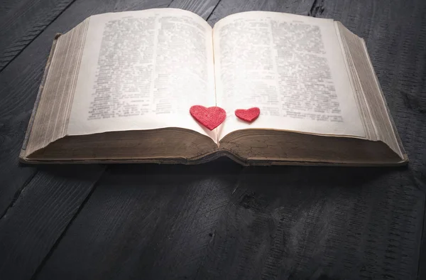 Zwei rote Herzen auf einem offenen Buch — Stockfoto