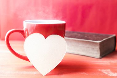 Kağıt kalp bir fincan sıcak kahve üzerinde