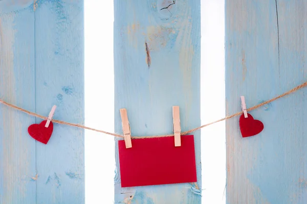 Nota de papel rojo y corazones en una cuerda — Foto de Stock