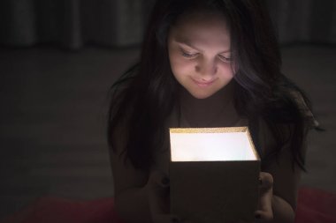 Bir kutu ile ışık tutan kadın