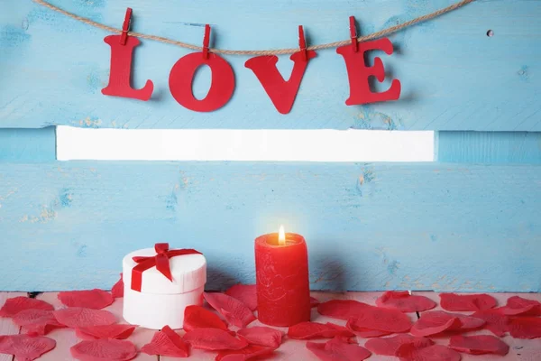 Geschenkschachtel und das Wort Liebe im Kerzenschein — Stockfoto
