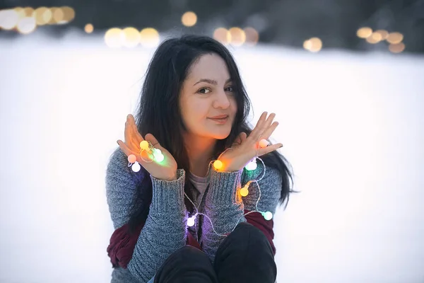 Uśmiechnięta brunetka kobieta trzymając światła string — Zdjęcie stockowe