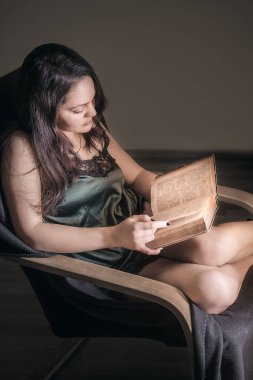 Seksi kadın bir koltukta okuma