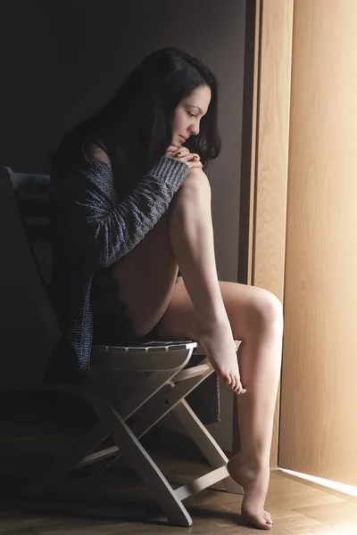 Bir sandalye üzerinde seksi esmer kadın — Stok fotoğraf