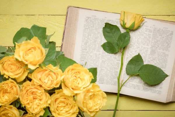 Gele roos op een open oud boek — Stockfoto