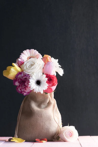 Ramo de flores de colores en una bolsa de yute — Foto de Stock