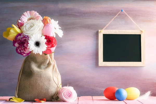 Flower bouquet with painted eggs and a chalkboard