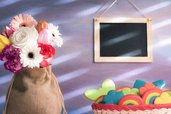 Πολύχρωμα μπισκότα και λουλούδια με ένα μαυροπίνακα — Φωτογραφία Αρχείου