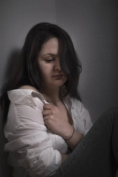 Mulher triste puxando sua camisa — Fotografia de Stock