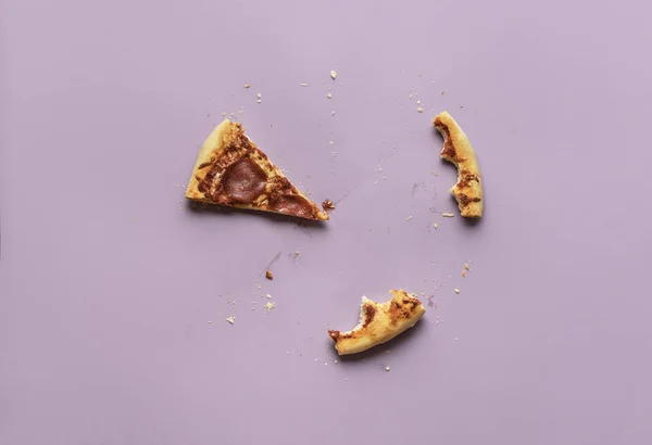 Bir dilim pizza ve arta kalanlar. Salamlı pizza, ekmek kırıntıları.